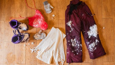 Dry wet snowy clothes on a warm floor in winter