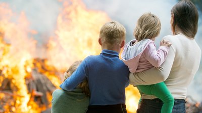 Family mother with children at burning house background