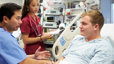 Male Patient Talking To Medical Staff In Emergency Room