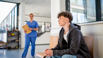 Teenage boy waiting alone in hospital waiting area