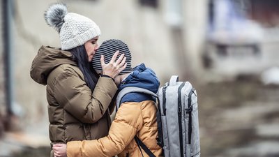 Woman kisses her boy on forehead outdoors