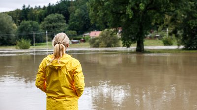 Worried woman looking at overflowing water during flood